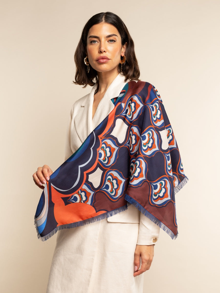 Woman wearing a colorful patterned scarf on a beige background