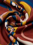 Close-up of colorful patterned fabric with swirls and geometric shapes.