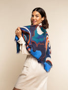 Woman wearing a colorful silk patterned scarf against a beige background