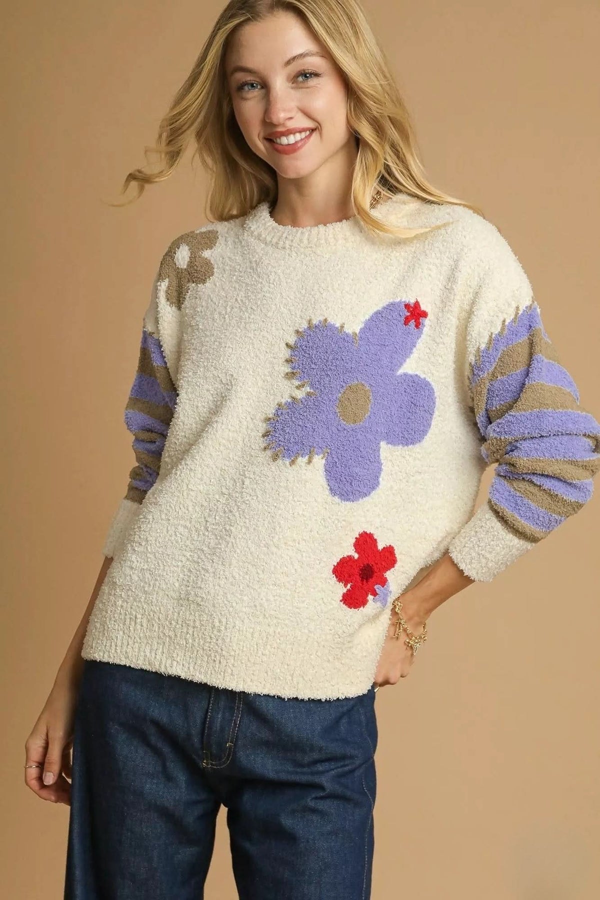 Cream textured floral sweater with oversized lavender flower, small red floral accents and striped long sleeves.