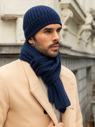 Man wearing a navy blue cashmere knit hat and scarf in an urban setting