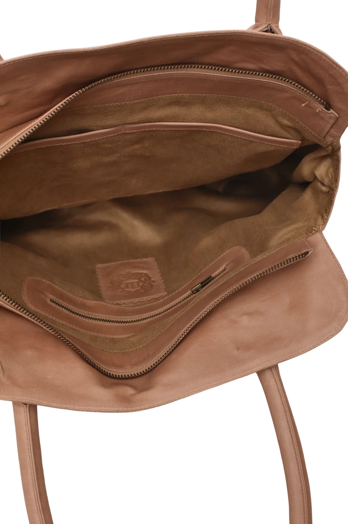 Close-up of a light brown suede interior of a beige leather bag with a visible brand logo on a white background