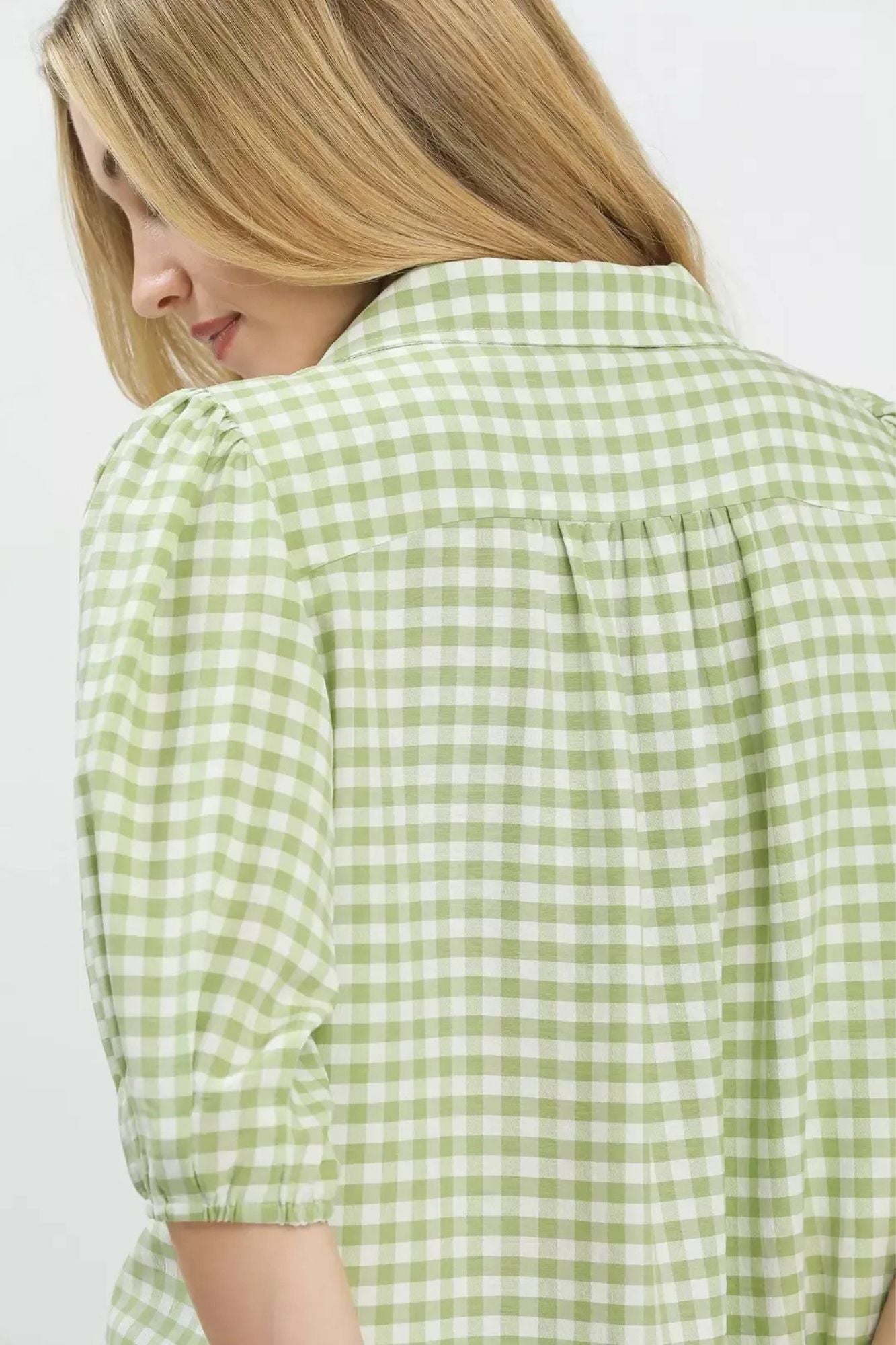 Model wearing a light green and white gingham check blouse, shown from the back-AVAH
