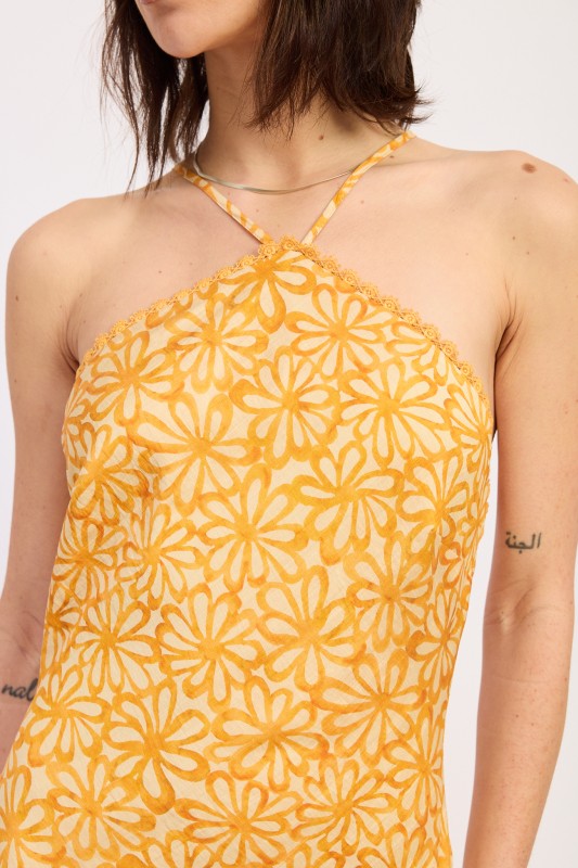 Woman wearing a Tangerine floral halter maxi dress front view closeup fitted silhouette summer dress on a white background