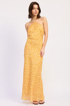 Woman wearing a Tangerine floral halter maxi dress front view fitted silhouette summer dress on a white background