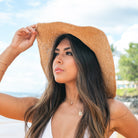 100% straw wide brim sun hat in khaki with Black bow accent