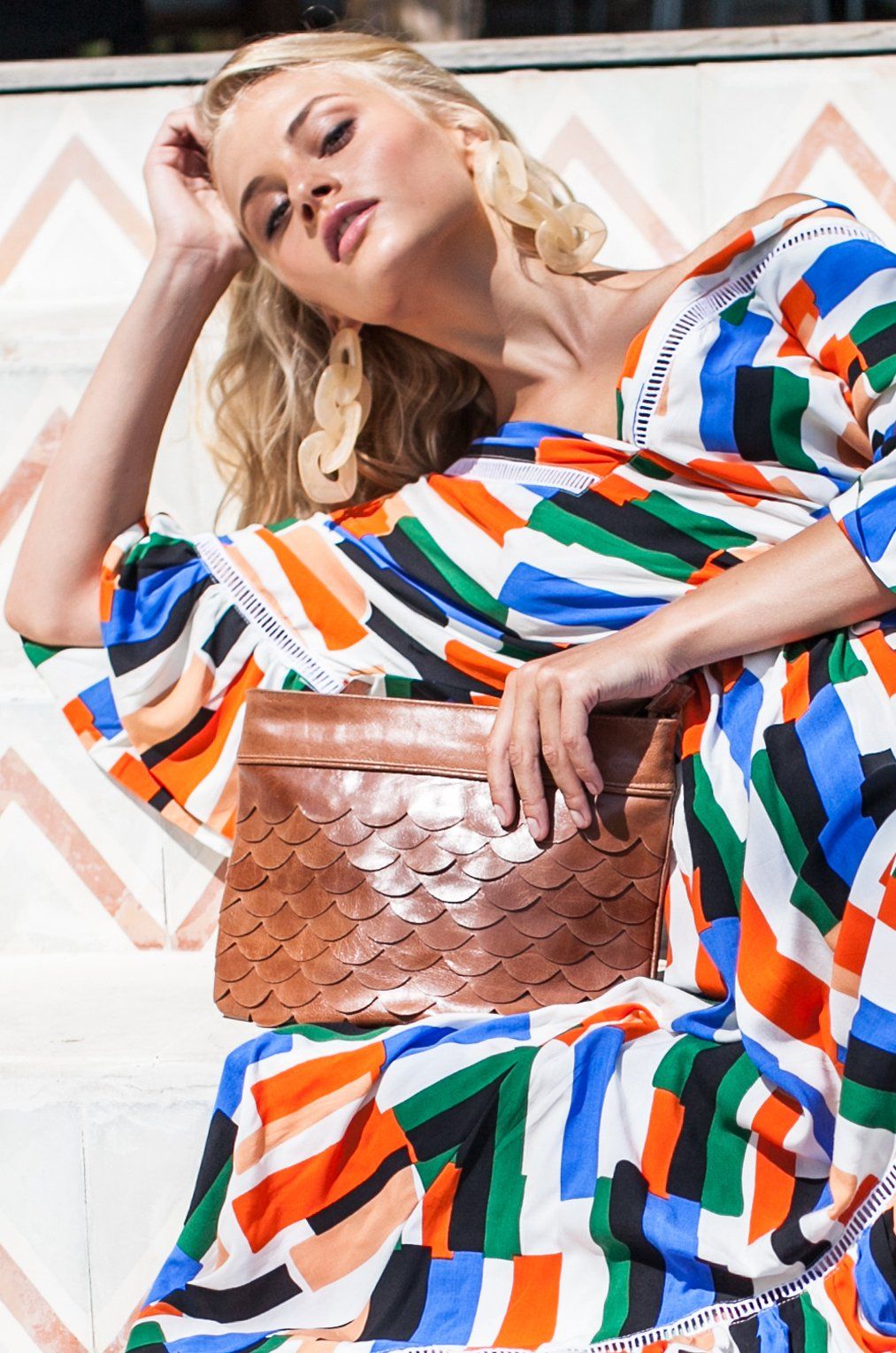 Model carrying the Cascade Leather Crossbody Clutch in vintage camel genuine leather