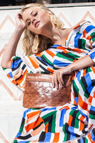 Model carrying the Cascade Leather Crossbody Clutch in vintage camel genuine leather