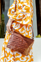 Model wearing the Cascade Leather Crossbody Clutch in vintage brown genuine leather
