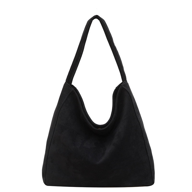 A black suede hobo shoulder bag with a single strap, photographed against a solid white background.
