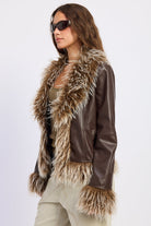 Side view of brown faux leather jacket featuring oversized faux fur collar, cuffs and hem.