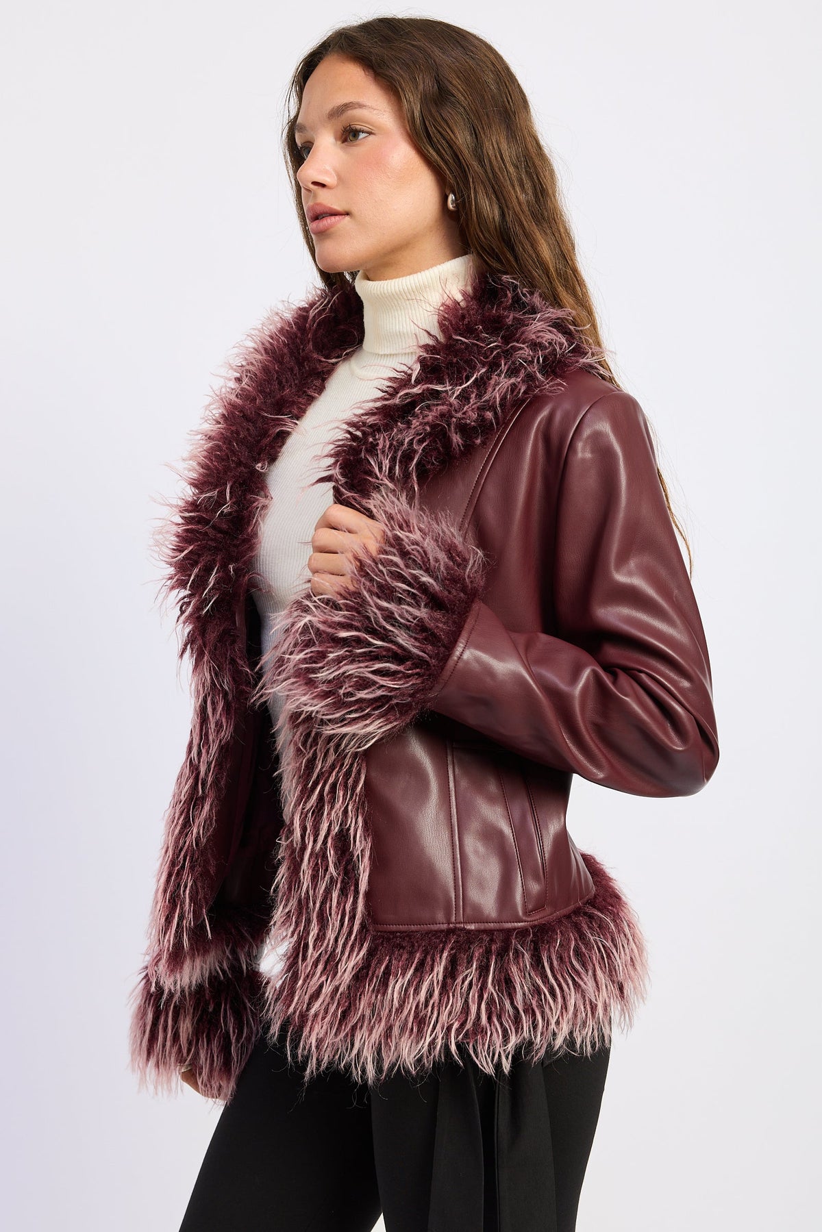 Side view of burgundy faux leather jacket showing contrasting shaggy faux fur trim and fitted silhouette.