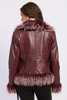 Back view of burgundy faux leather jacket with seam detailing and shaggy faux fur collar, cuffs and hem.