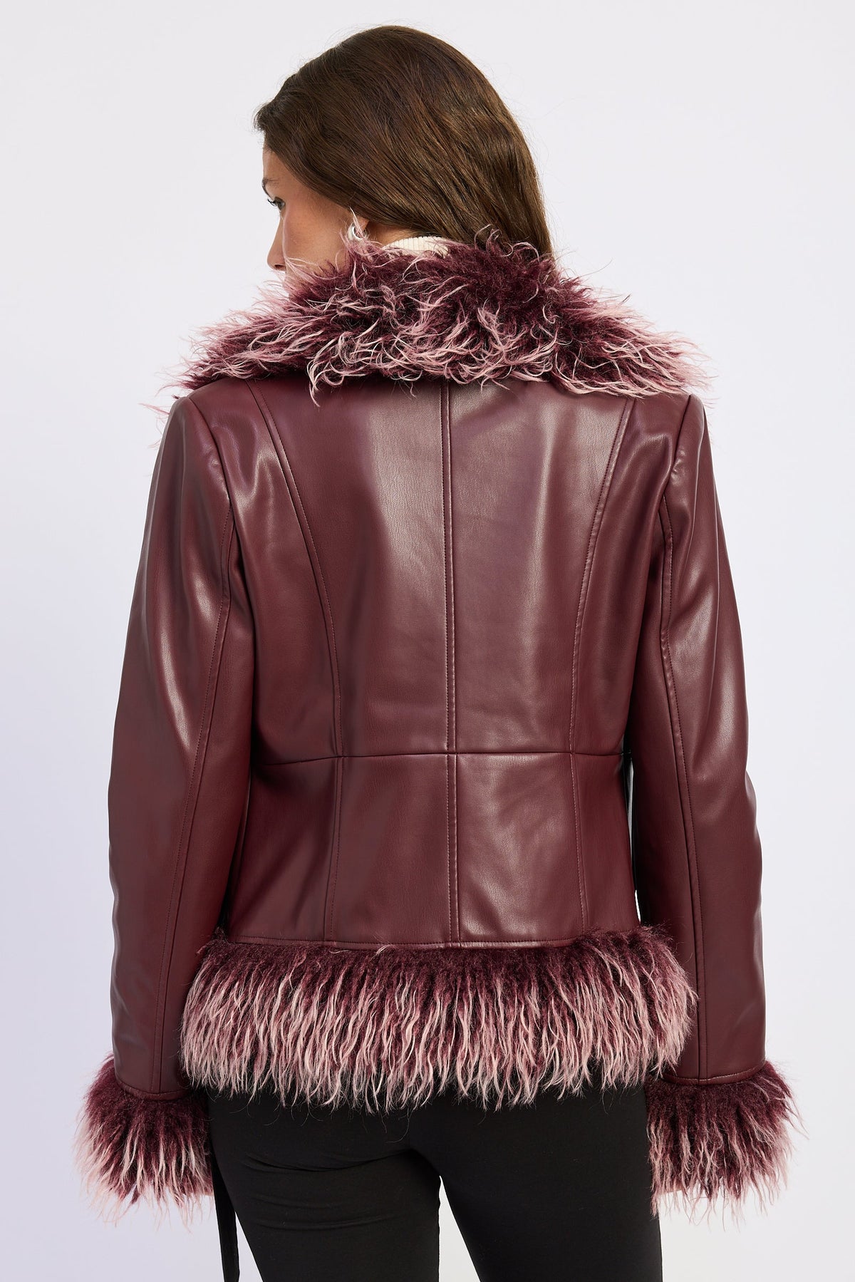 Back view of burgundy faux leather jacket with seam detailing and shaggy faux fur collar, cuffs and hem.