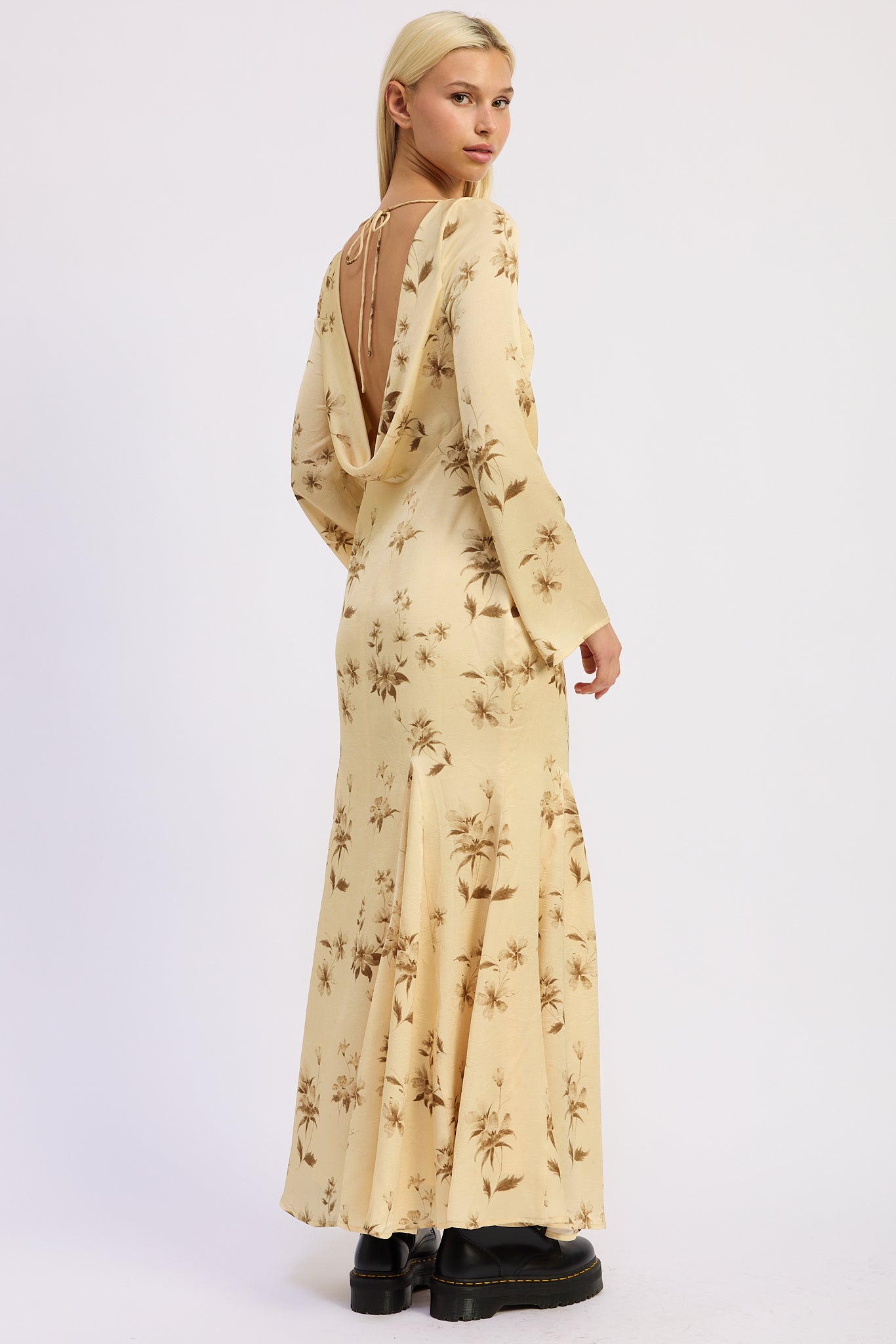 Woman wearing a long-sleeve, floral-patterned maxi dress with open back on a white background back view 