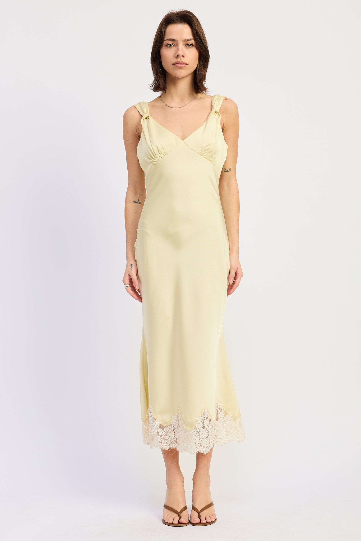 Woman wearing bias-cut satin midi dress with lace hem in Butter Yellow.