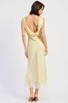 Woman wearing bias-cut satin midi dress with lace hem in Butter Yellow.