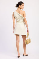 Woman wearing an ivory one-shoulder mini dress against a white background back view