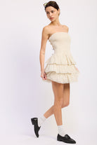 woman wearing cream strapless smocked tiered mini dress front view on white background front angle view