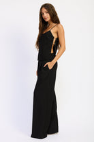 Side view of Marlowe Black Wide Leg Pants showing wide leg cut, tailored waistband and flowing length.
