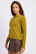 Side view of moss green button front cardigan showing the close fitting silhouette and ribbed hem.