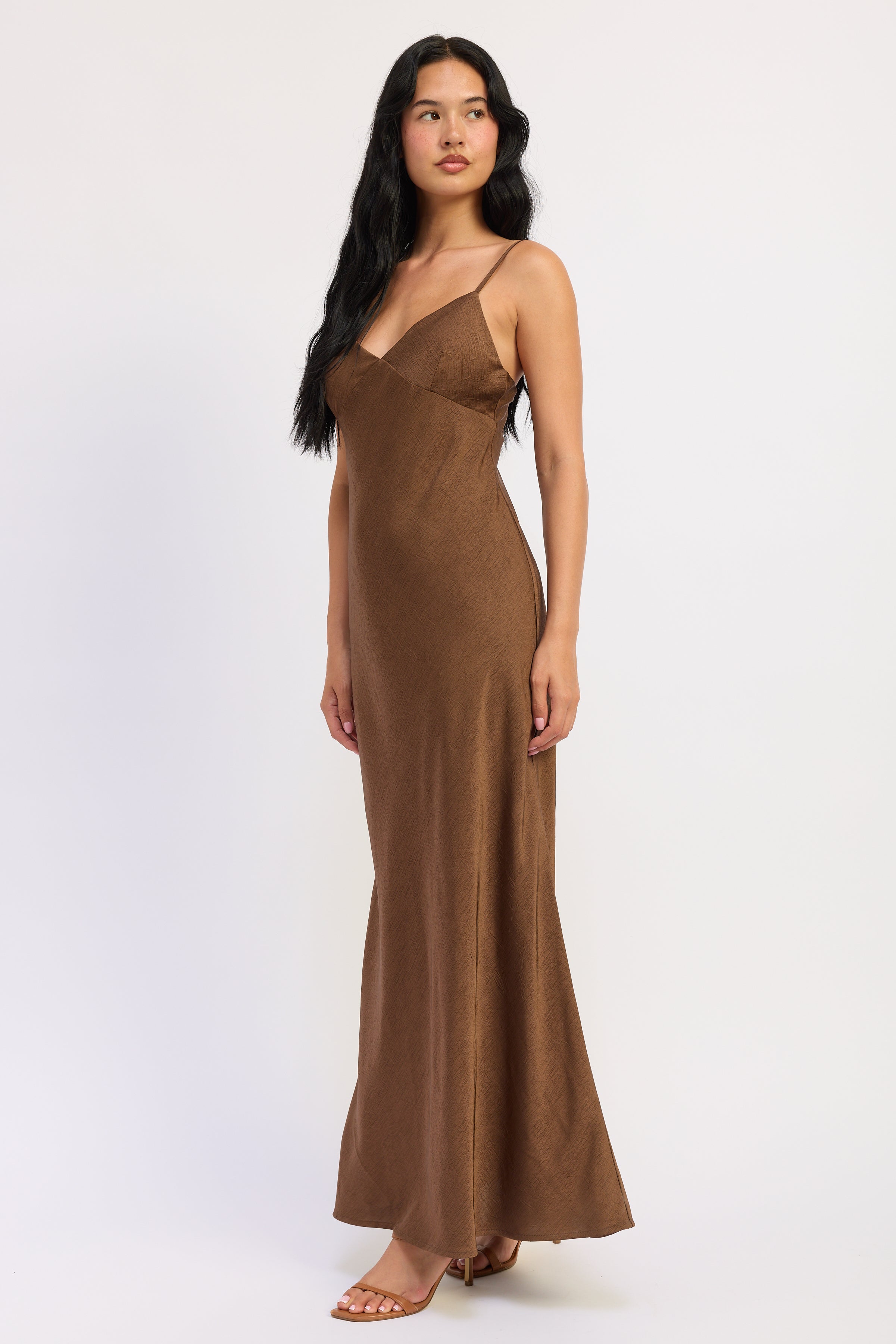 Side view of Sienna Satin Slip Dress in brown showing textured satin fabric and gently flared hem.