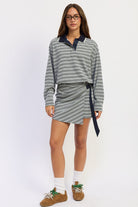 Model wearing heather grey Varsity Club Striped Polo Mini Dress with navy stripes, contrasting collar and wrap-style mini skirt.