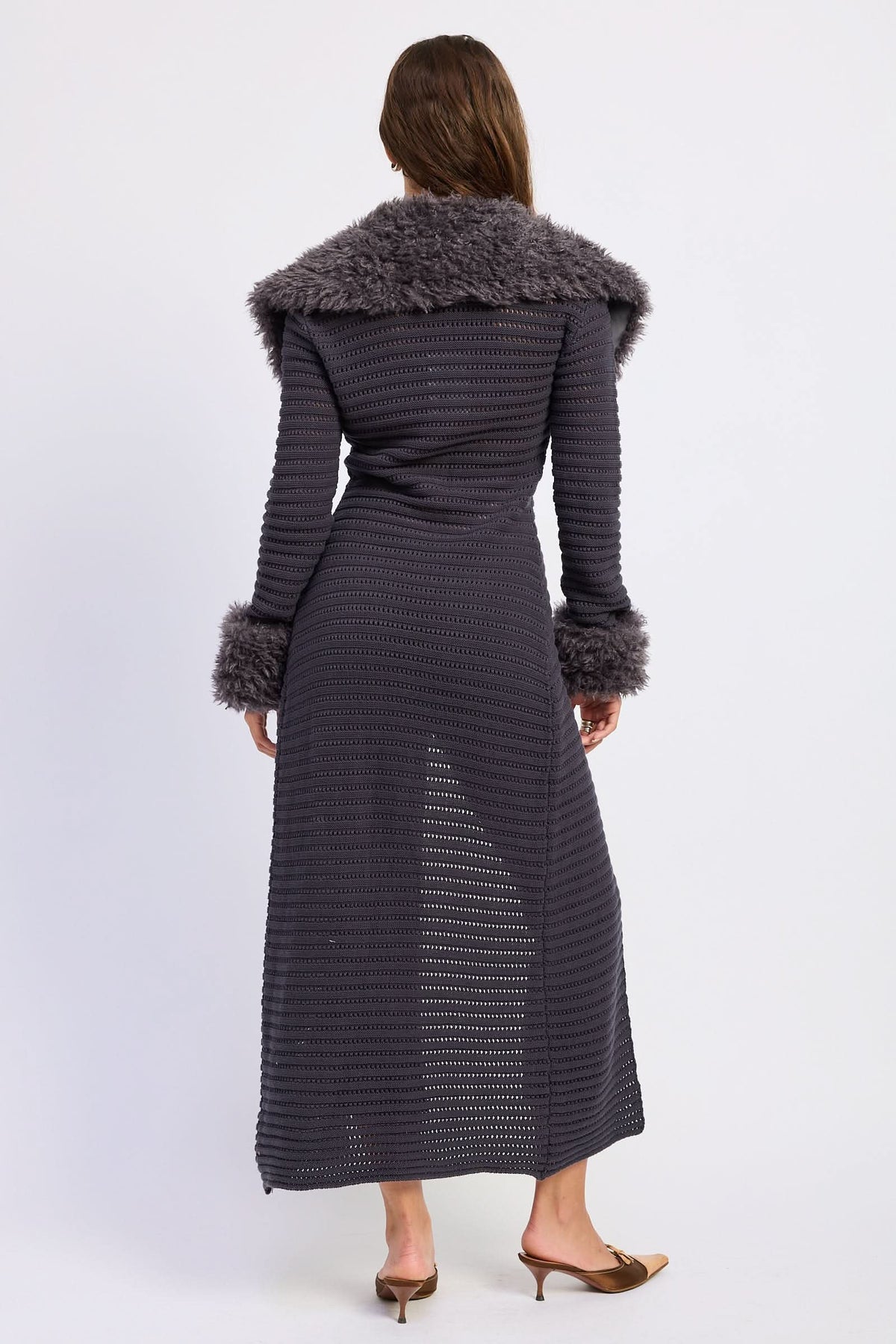 Woman wearing grey longline cardigan, back view showing wide plush collar against white background.