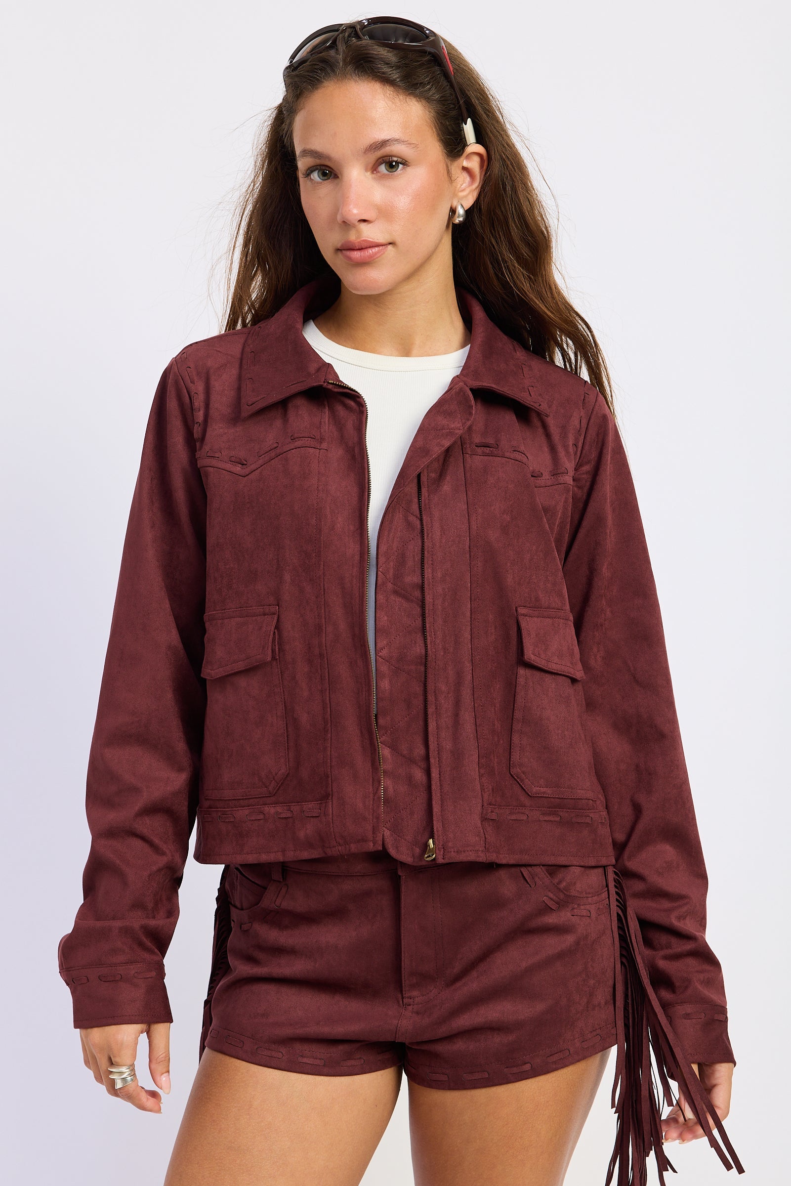 Wine faux suede fringe jacket with collared neckline, front pockets and tonal whipstitch detailing
