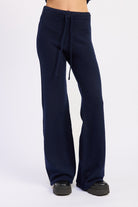Front detail of navy knit pants with adjustable drawstring waist and relaxed wide legs.