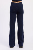 Back view of navy wide leg knit pants showing smooth waistband and straight leg shape.
