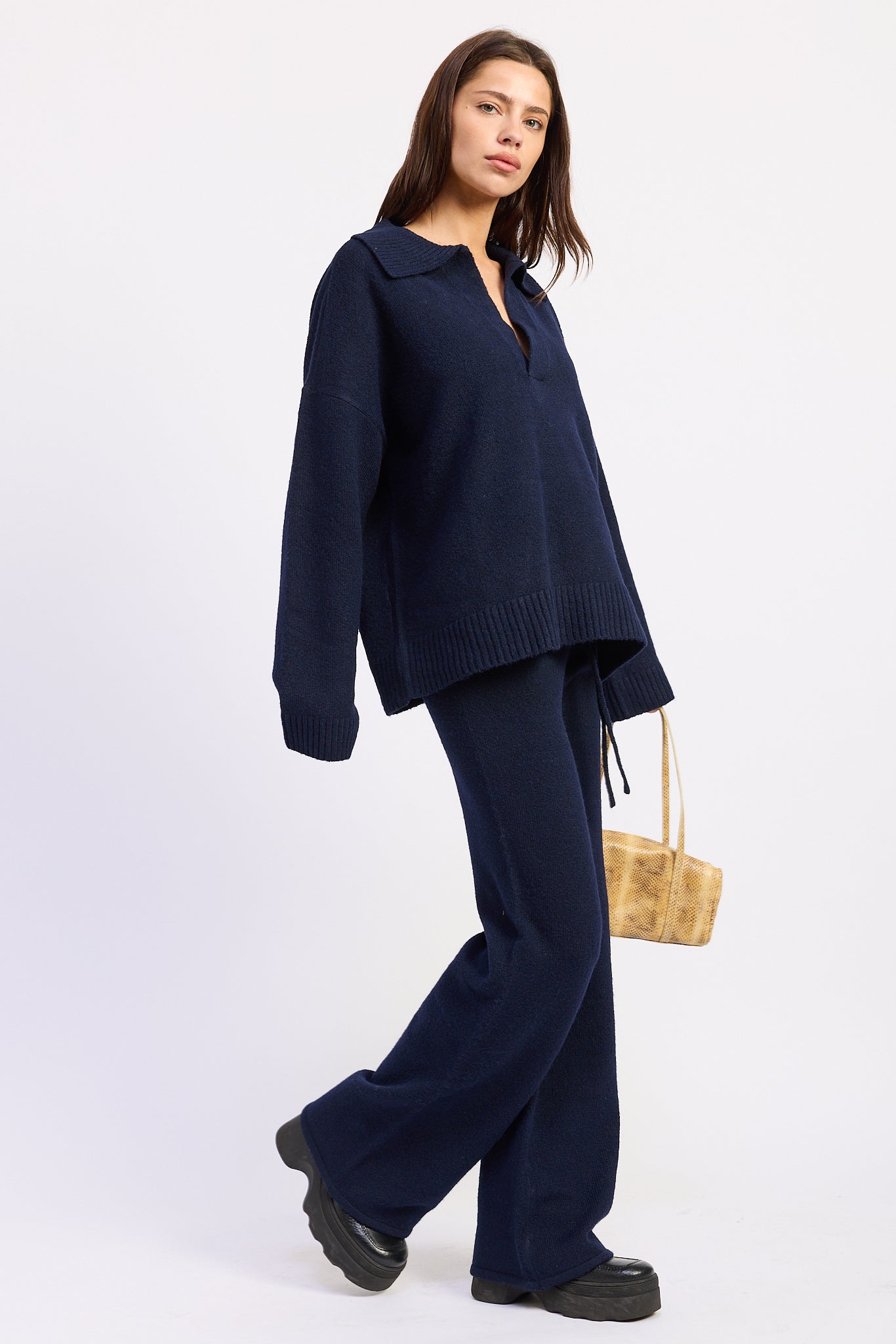 Side view of lounge navy knit pants showing relaxed wide leg fit and full length silhouette.