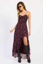 Woman wearing polka dot maxi dress with spaghetti straps and ruffled asymmetric hem in Wine.