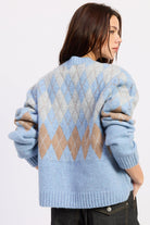 Back view of baby blue argyle zip cardigan with grey and camel diamond pattern and ribbed hem.