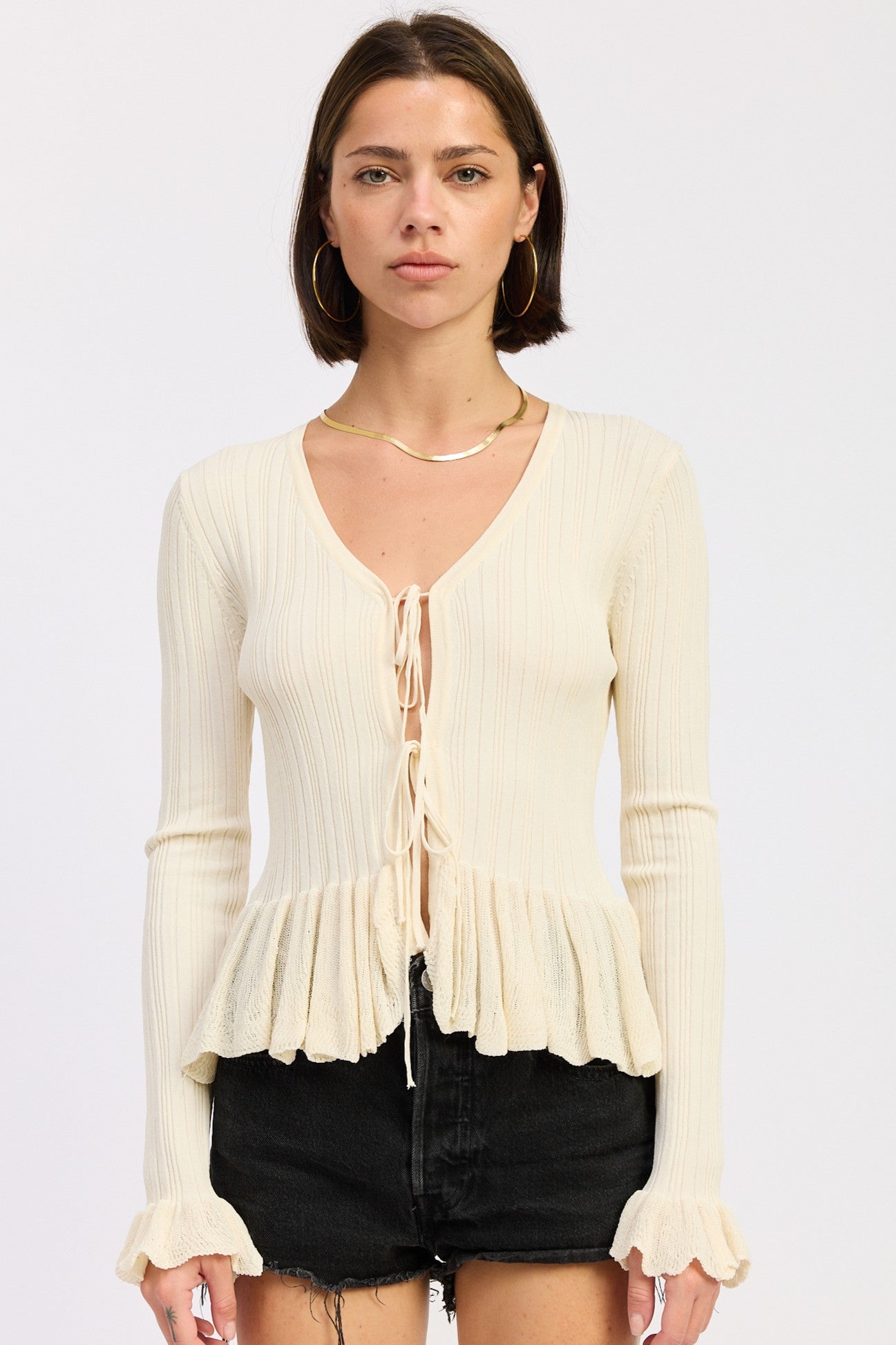 Ivory ribbed tie front knit cardigan with peplum hem and ruffled cuffs
