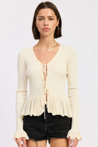 Ivory ribbed tie front knit cardigan with peplum hem and ruffled cuffs
