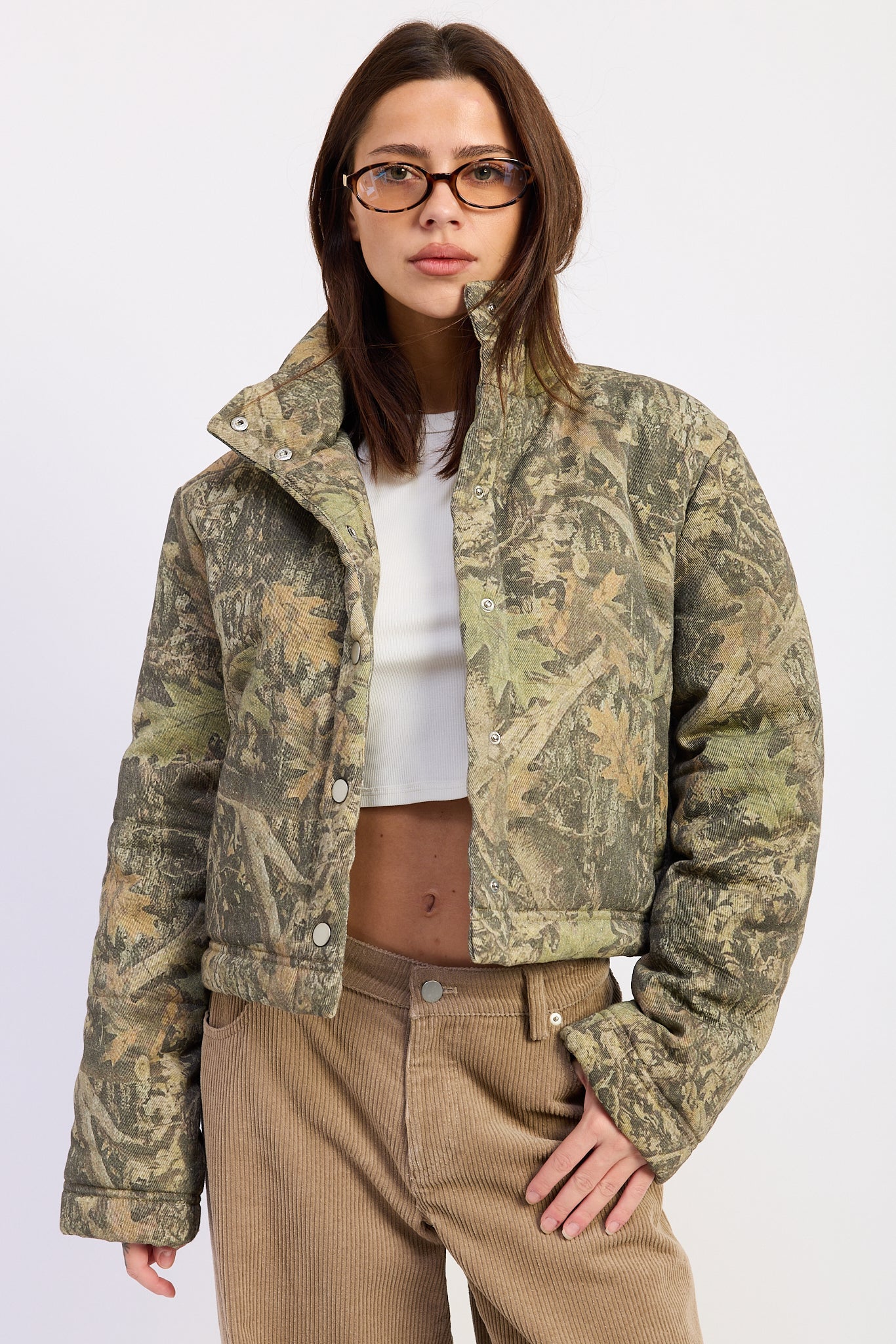 Wildwood camo puffer jacket with woodland print, oversized stand collar and snap front closure, front view.
