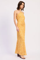 Woman wearing a Tangerine floral halter maxi dress front angle view fitted silhouette summer dress on a white background