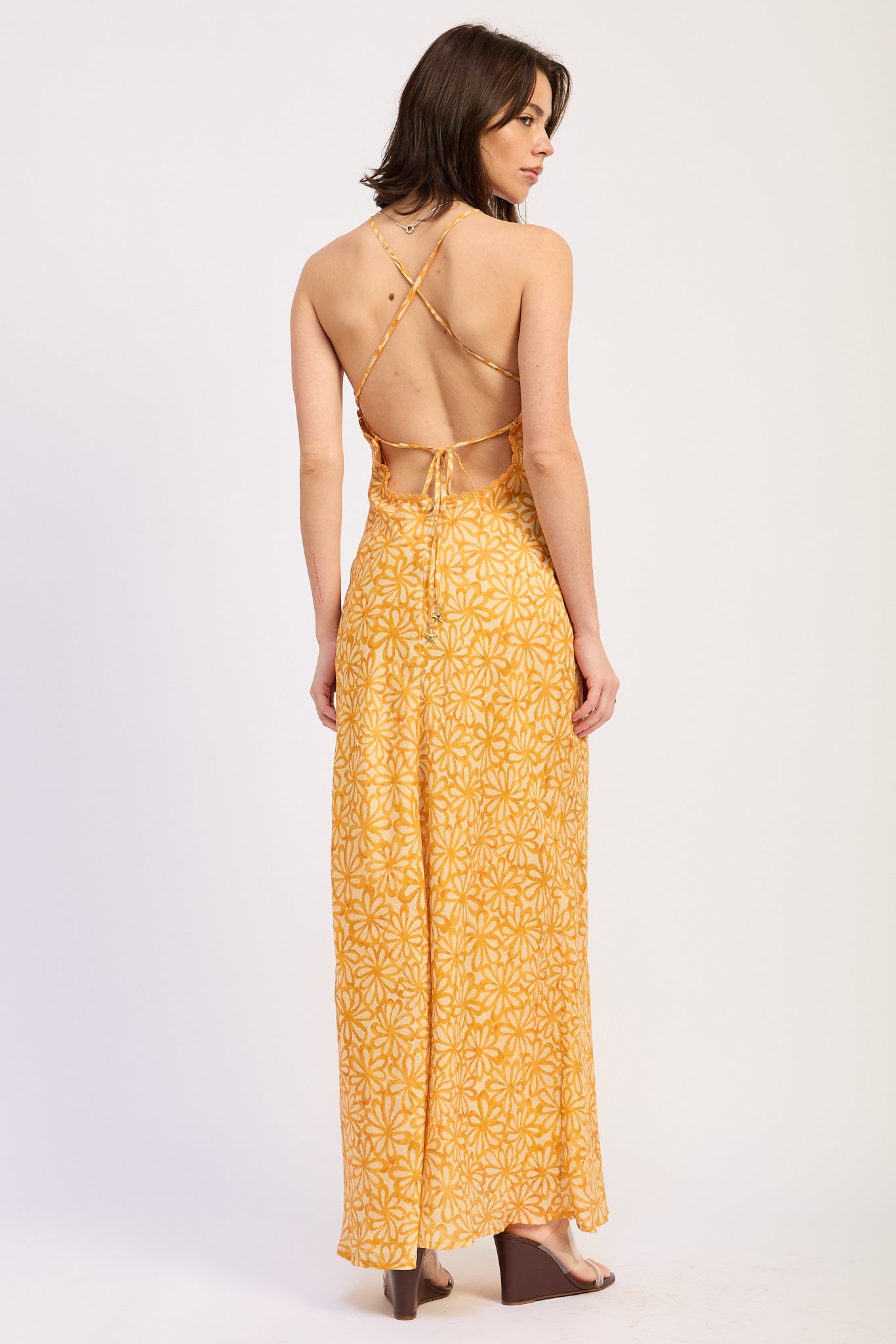 Woman wearing a Tangerine floral halter maxi dress back view fitted silhouette summer dress on a white background