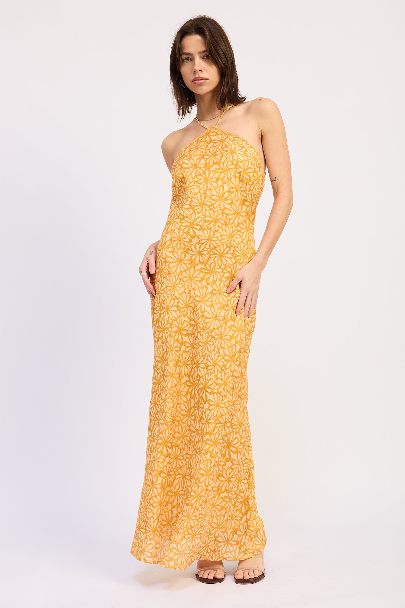 Woman wearing a Tangerine floral halter maxi dress front view fitted silhouette summer dress on a white background