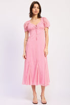 Model wearing a pink pinstripe midi dress with puff sleeves, a tie front neckline, fitted bodice, and flared skirt styled with clear wedge sandals.