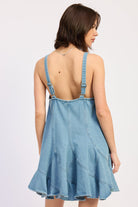 Woman wearing a light blue denim dress against a white background, front view back view