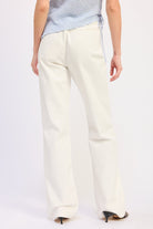 Woman wearing Buckle Wide Leg cream color cotton Pants on a white background back view