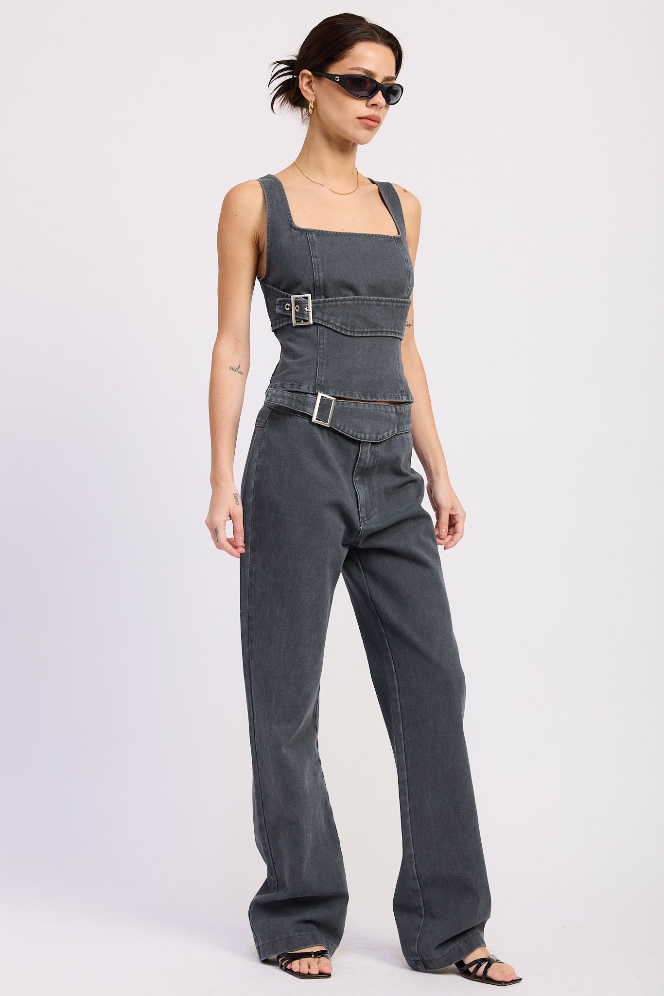Woman wearing Buckle Wide Leg denim color cotton Pants on a white background front angle view