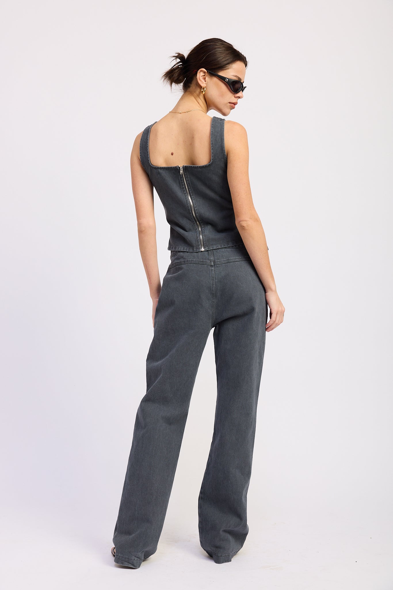 Woman wearing Buckle Wide Leg denim color cotton Pants on a white background back view
