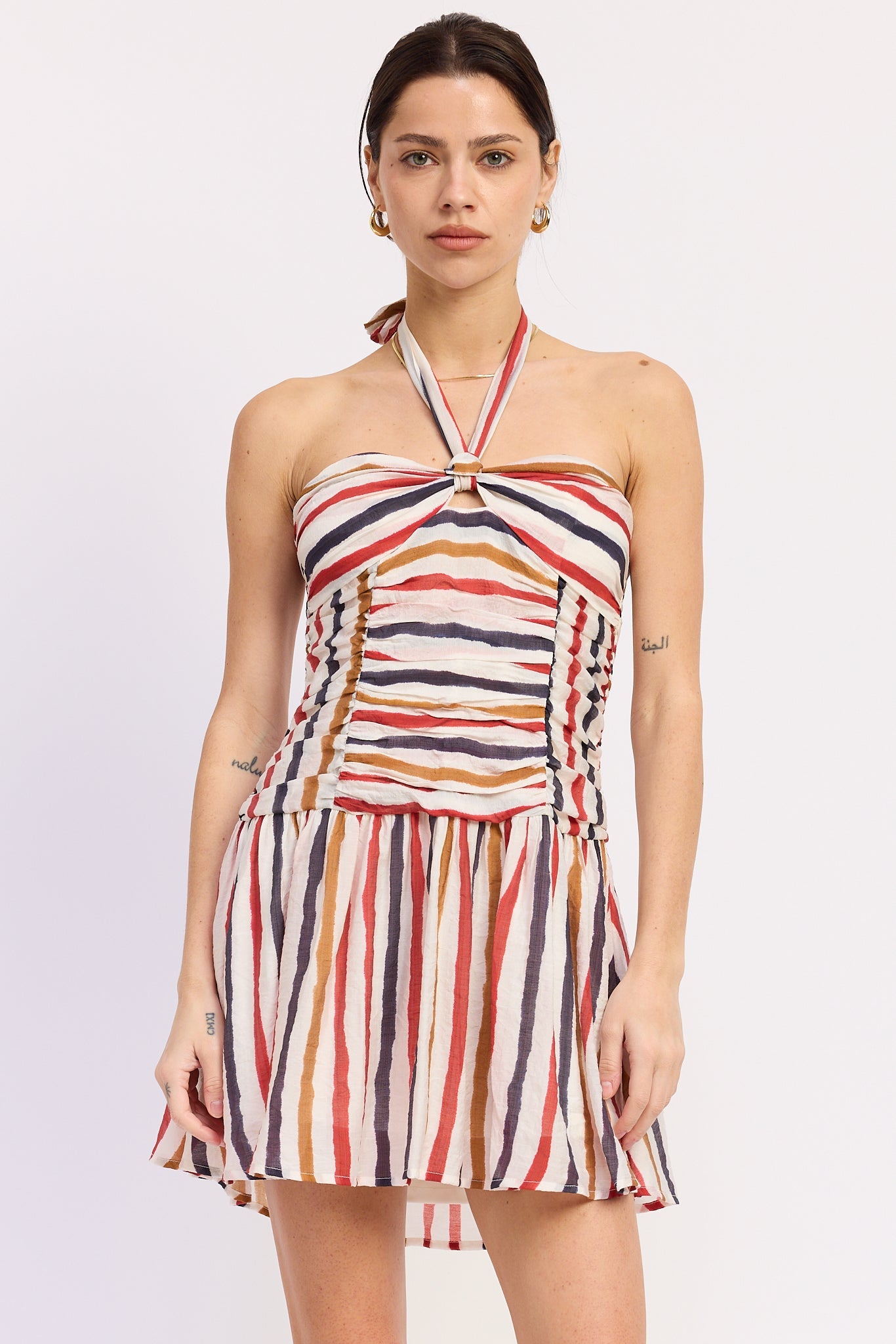 Woman wearing a striped halter mini dress front view with multicolor vertical stripes on a white background