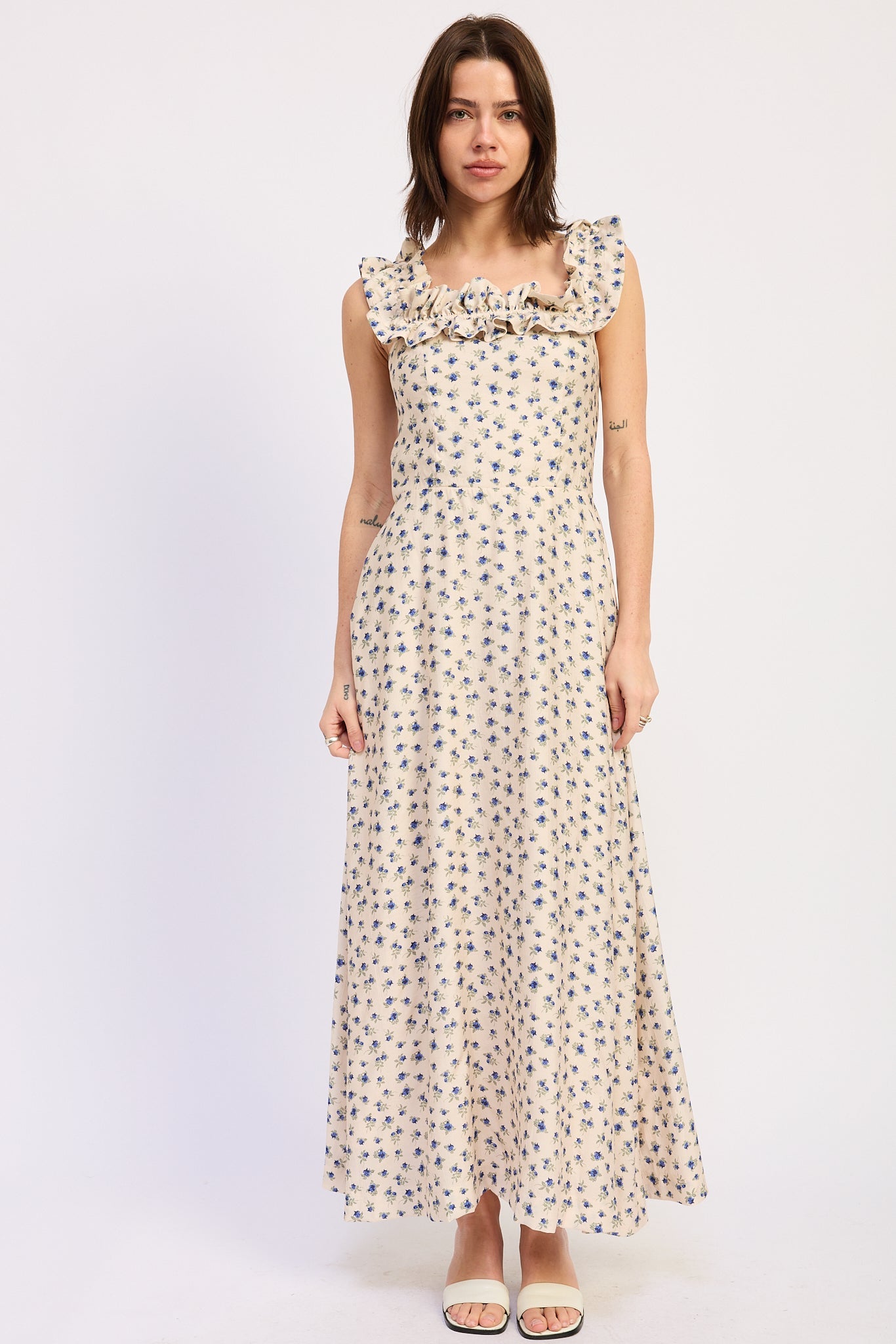 Woman wearing an Ivory floral ruffle maxi dress front view with blue floral print on a white background