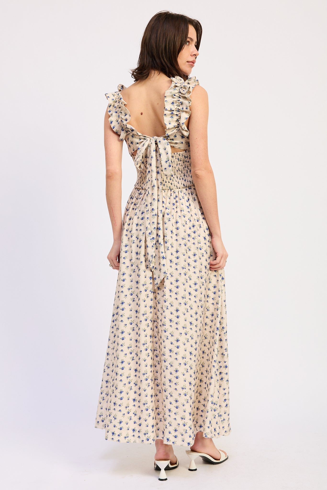 Woman wearing an Ivory floral ruffle maxi dress front view with blue floral print on a white background back view