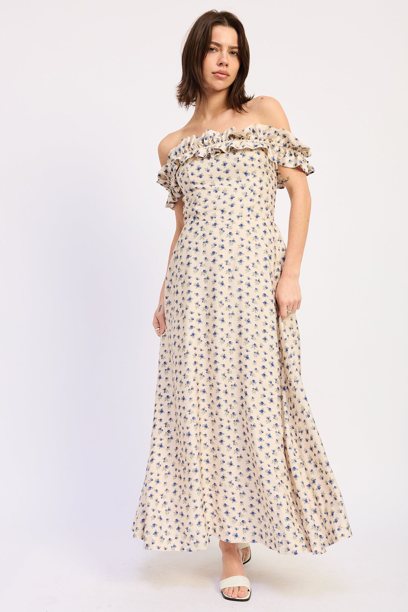 Woman wearing an Ivory floral ruffle maxi dress front view with blue floral print on a white background front view