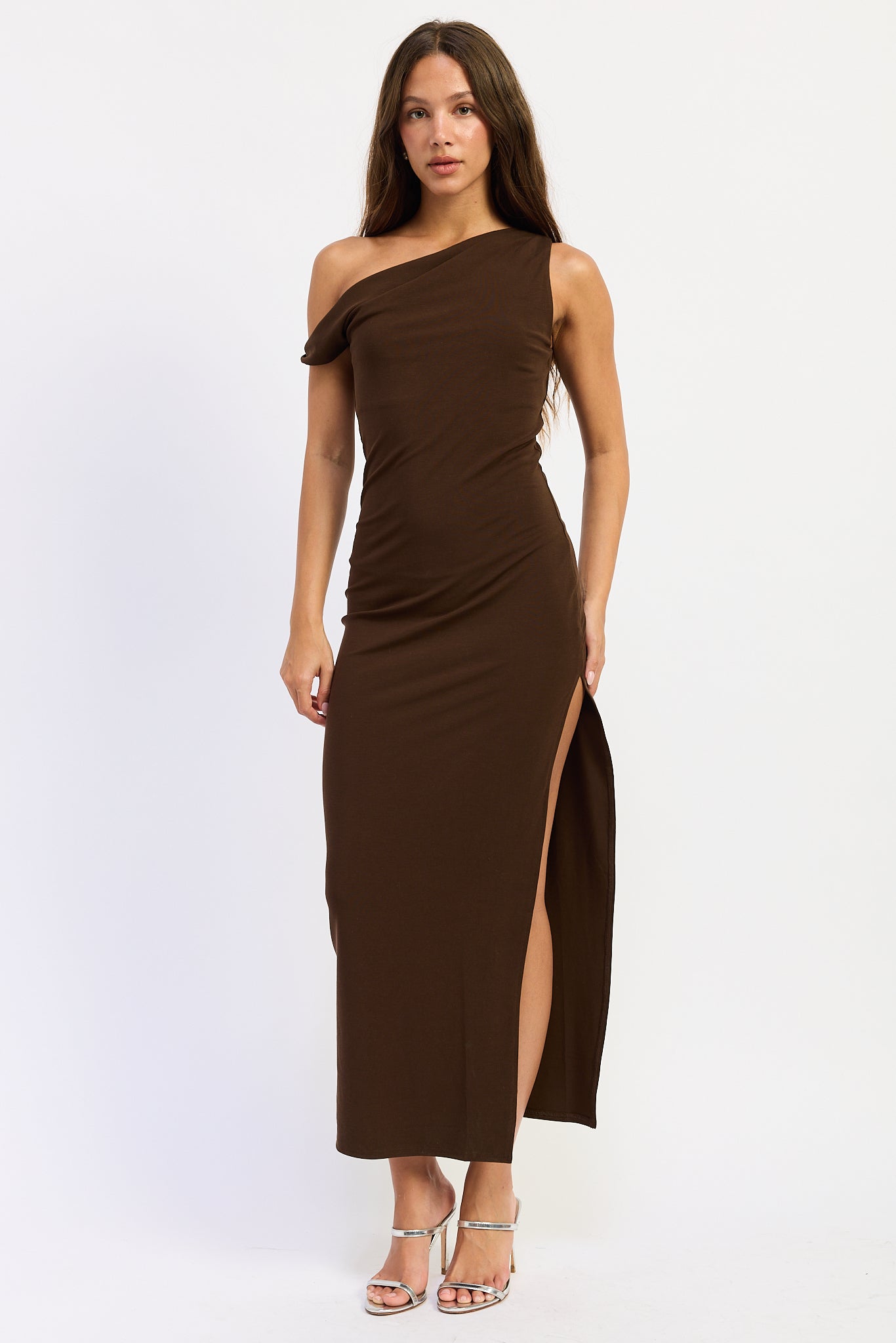 Brown one shoulder maxi dress with draped neckline and high side slit, front view.